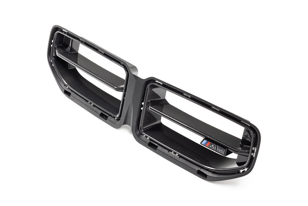 Alpha N G87 M2 LCI front grille emblem retainer with BMW OEM M2 badge installed on the vehicle exterior.