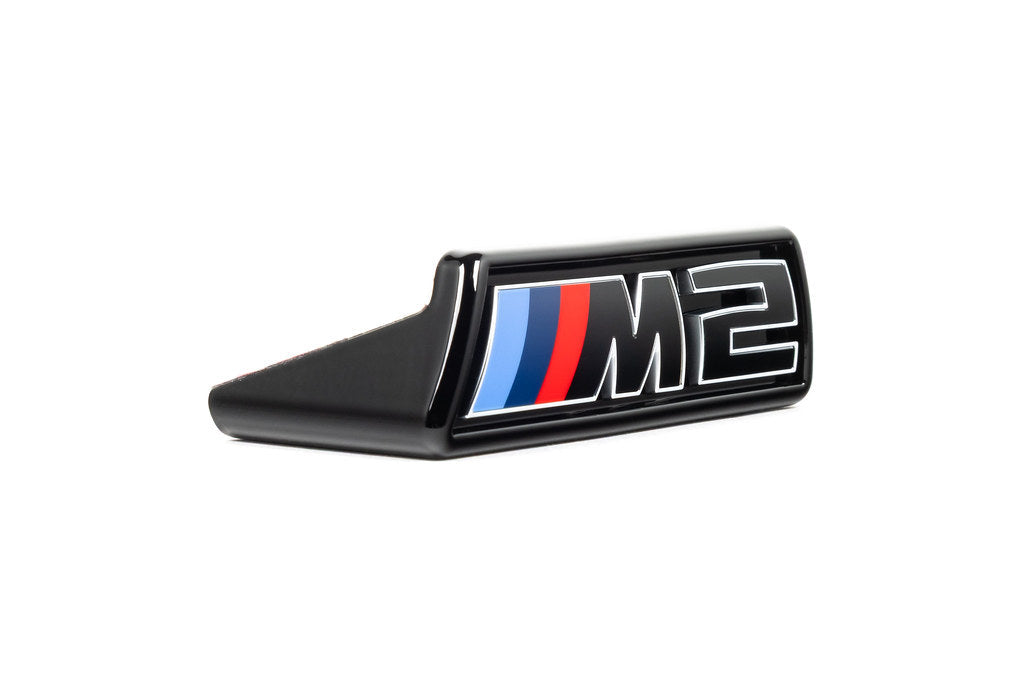 Alpha-N G87 M2 LCI front grille emblem retainer with BMW OEM M2 badge on white background. Exterior car accessory.