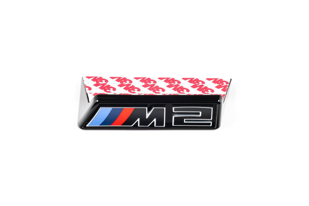 Alpha-N G87 M2 LCI front grille emblem retainer with BMW OEM M2 badge on a white background.